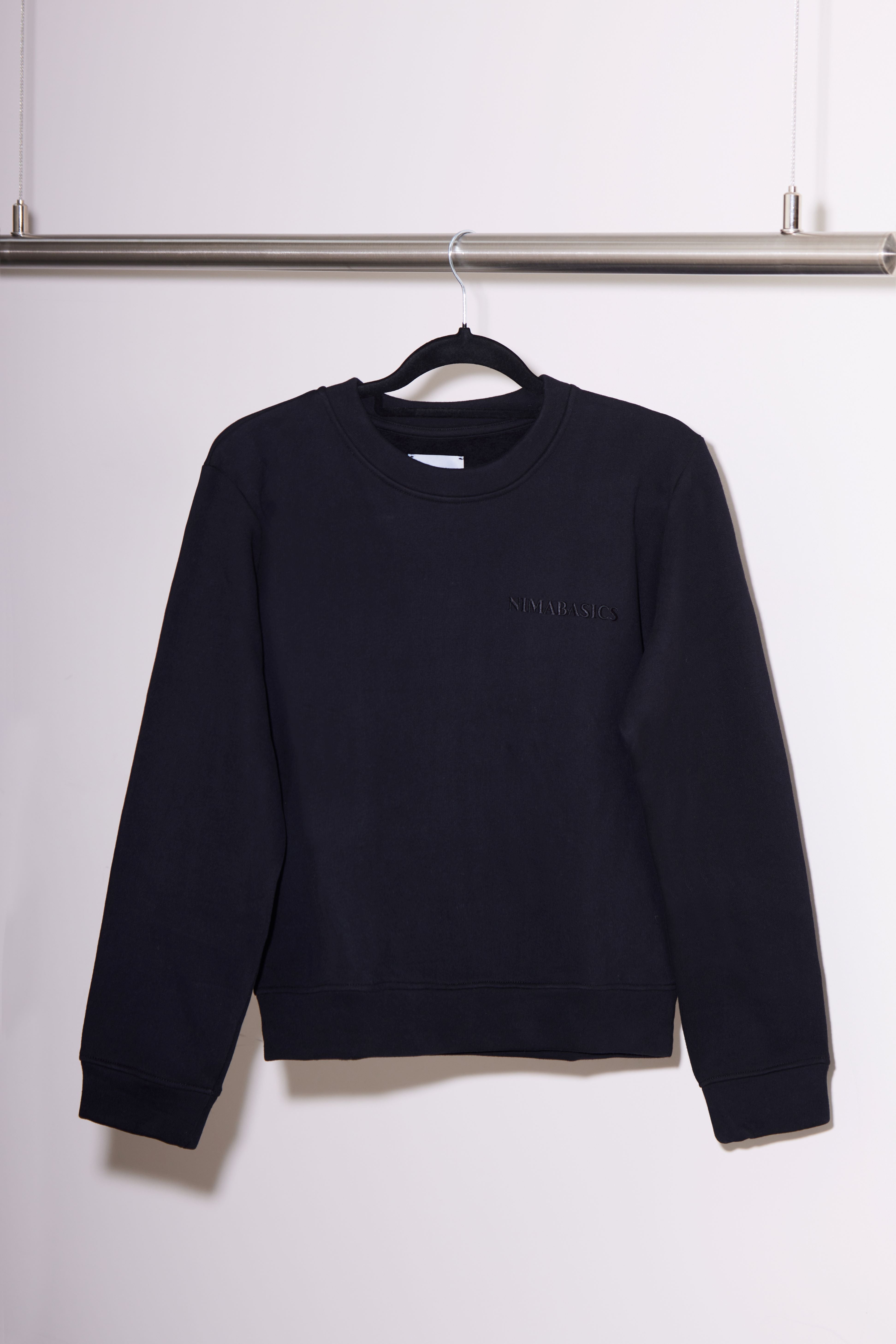 Sweater hängt an einer Kleiderstange